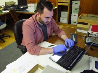 Researcher John Andrew Campbell recording details about objects in the Peabody collection